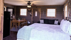 A cozy cabin-style room with a bed, a desk, and a chair. - Knots Landing - A romantic getaway w/ hot tub (Afton)