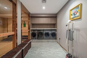 Un cuarto de lavandería con lavadora, secadora y un tendedero.