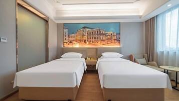 Habitación de hotel con dos camas individuales, un cuadro de un paisaje urbano en la pared, una mesita y una silla.