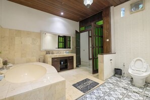 A bathroom with a bathtub, sink, mirror, and toilet. - The Lavana Ziza Living And Villas Seminyak (Bali)
