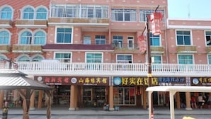 A multi-story building with a row of shops on the ground floor. - Chaoyang Hotel (Putian)