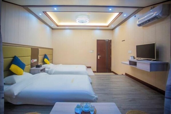 A hotel room with two beds, a TV, a ceiling light, and an air conditioner. - Chaoyang Hotel (Putian)