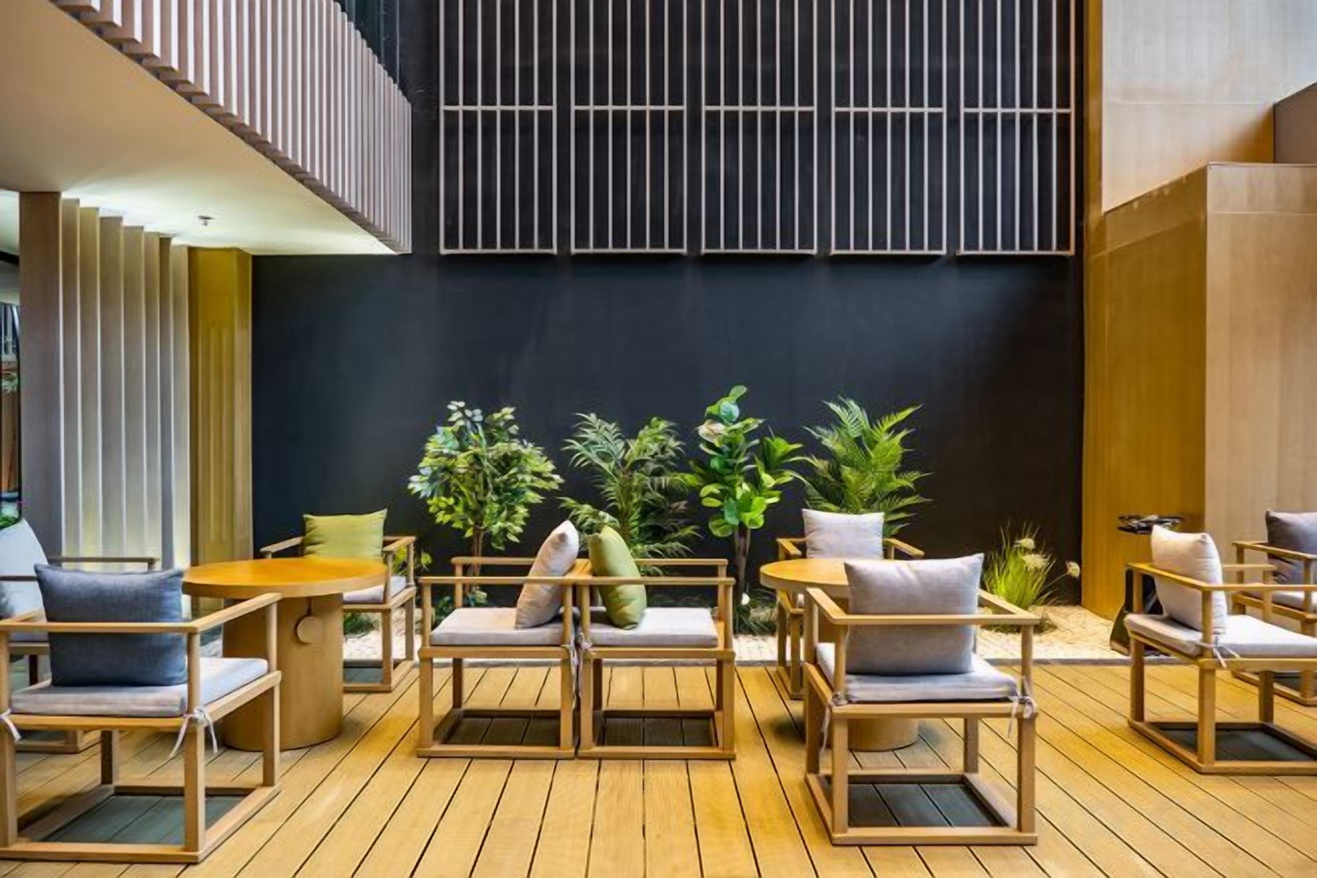 A modern outdoor seating area with wooden furniture and potted plants.
