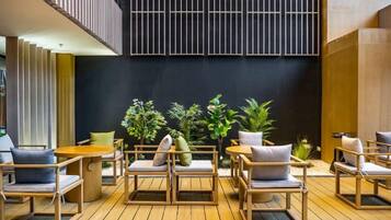 A modern outdoor seating area with wooden furniture and potted plants.