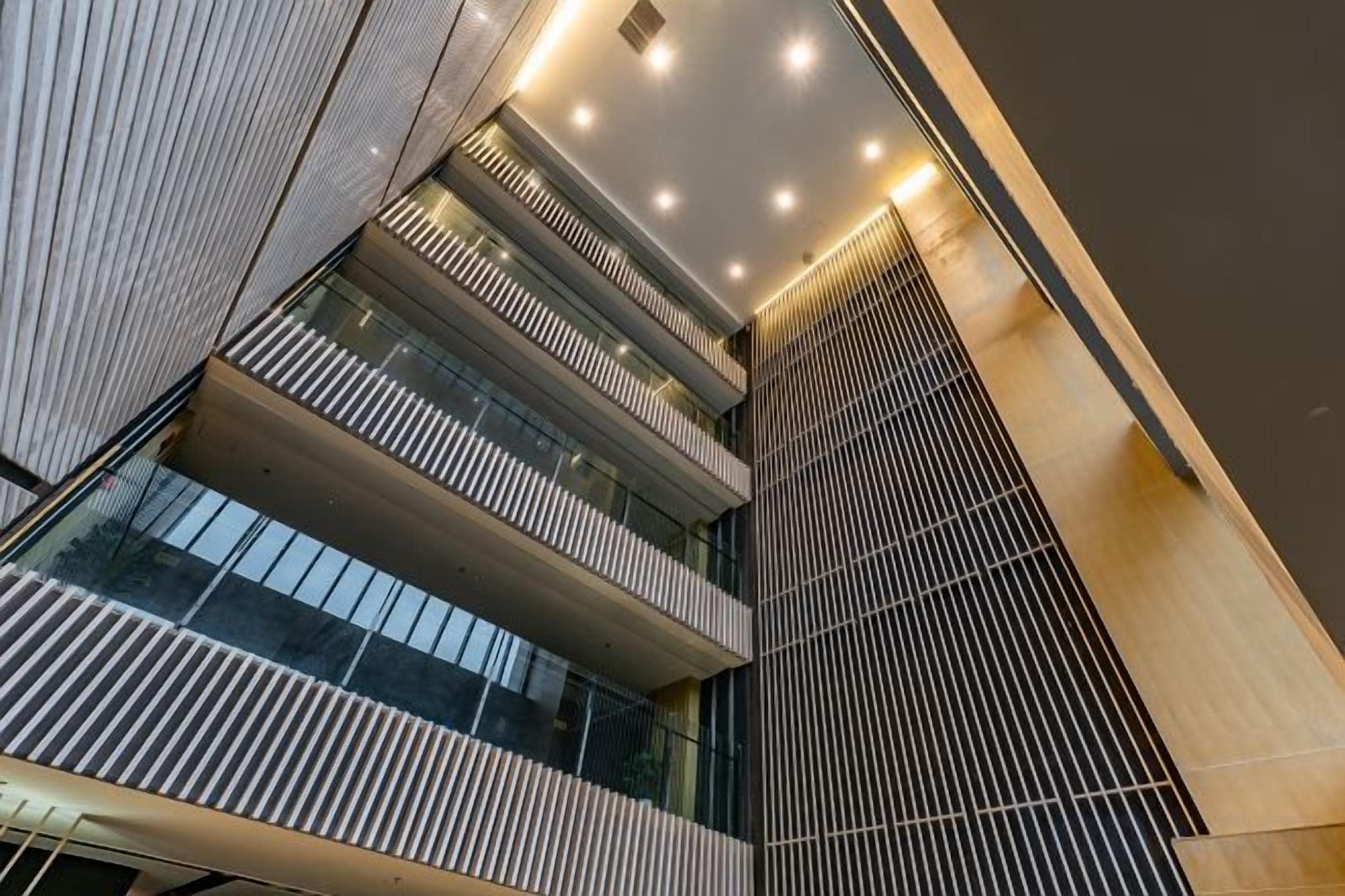A multi-level interior with a modern design, featuring a series of balconies and a central open space.