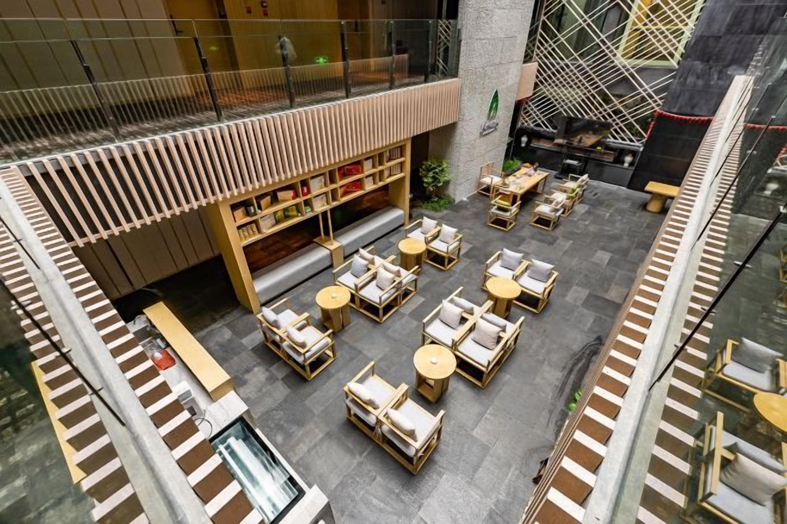 An indoor courtyard with seating areas, a staircase, and a building with a modern design.