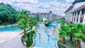 A resort with a swimming pool, water slides, palm trees, and a building with multiple floors. - Tangtaizong Hot Spring Resort (Lushan City)