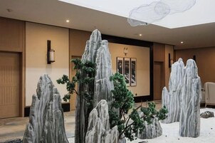 Un vestíbulo con jardín de rocas y un cuadro enmarcado en la pared.