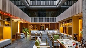 A spacious, modern interior with a central seating area, wooden furniture, and a mezzanine level. - Tangtaizong Hot Spring Resort (Lushan City)