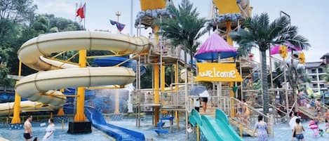 A water park with multiple slides and a 'Welcome' sign.