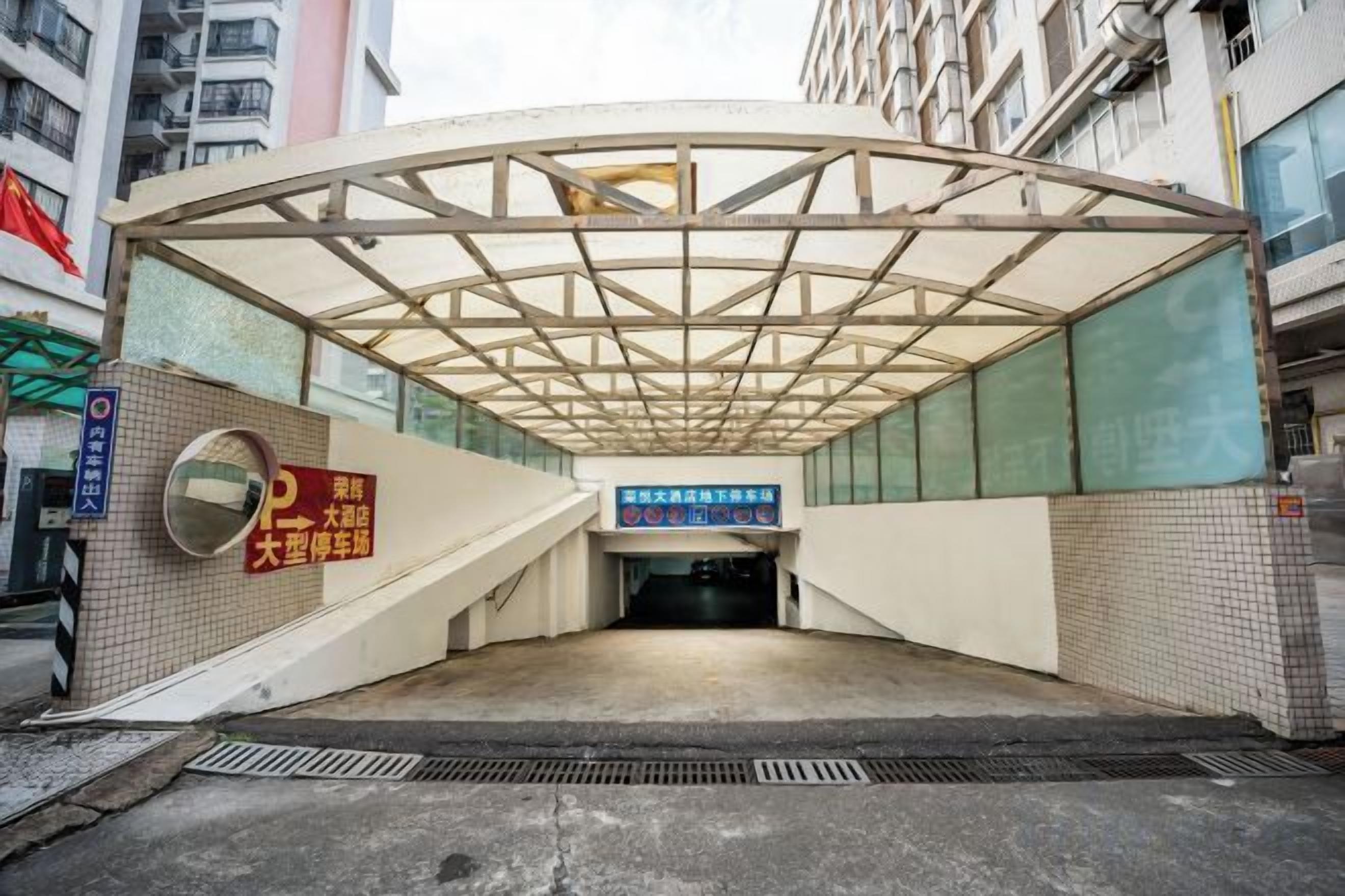 An underground parking structure with a covered entrance, signage, and a tiled wall.