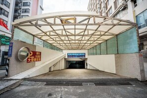 Un pàrcing subterrani amb entrada coberta, senyalització i paret de rajoles.