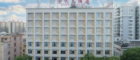 A multi-story hotel with a uniform facade, numerous windows, and a clear sky.