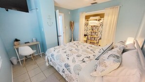 Un dormitorio con cama, escritorio, silla y armario.