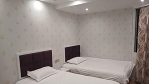 A hotel room with two beds, a nightstand, and a window with curtains. - Jinhua Lianyi Hotel (Jinhua)