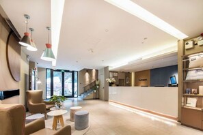 A hotel lobby with a reception desk, seating area, and a staircase leading to another floor. - Home Inn Neo Shenzhen East Railway Station Changlong Metro Station (Shenzhen)