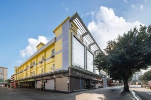 A multi-story building with a yellow facade and a large glass window on the upper floor. - Home Inn Neo Shenzhen East Railway Station Changlong Metro Station (Shenzhen)