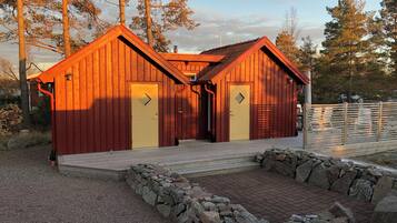 Una baita di legno con due porte e un piccolo portico.