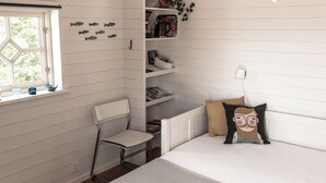 A bedroom with a bed, a chair, a shelf with books, a window, and a small plant. - Charming 2-bedroom house new built in wonderful Grebbestad  (Grebbestad)