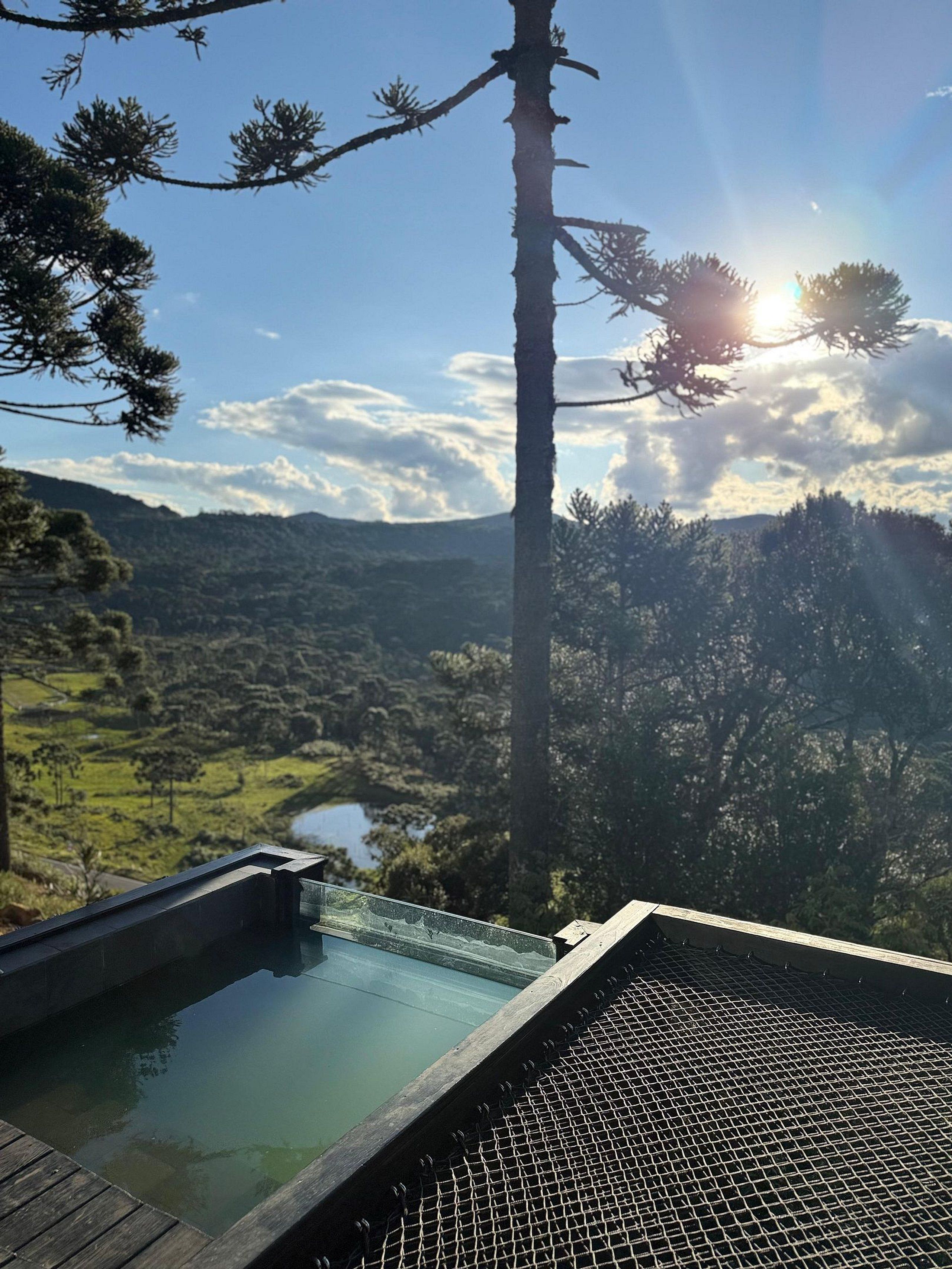 Una piscina con vistas a un valle y una cordillera.