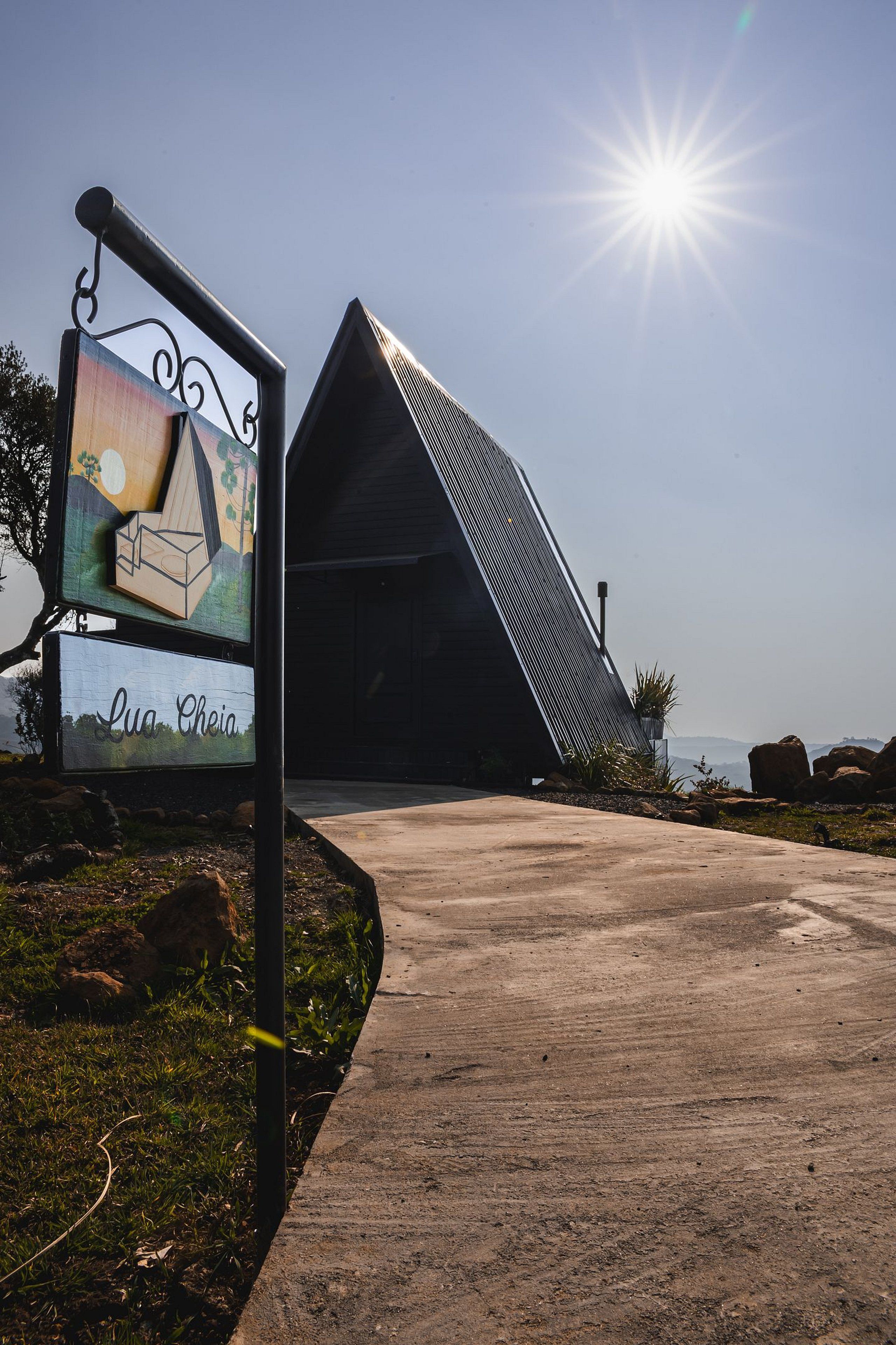 Un bâtiment moderne doté d’un toit en pente et d’une enseigne représentant une illustration d’une maison, ainsi que le nom « Lu Cheia ».