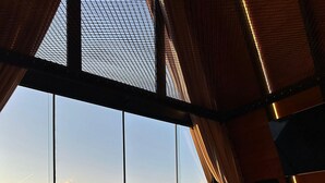 Ein modernes Interieur mit großen Fenstern, einem Holzboden und einem Kamin.