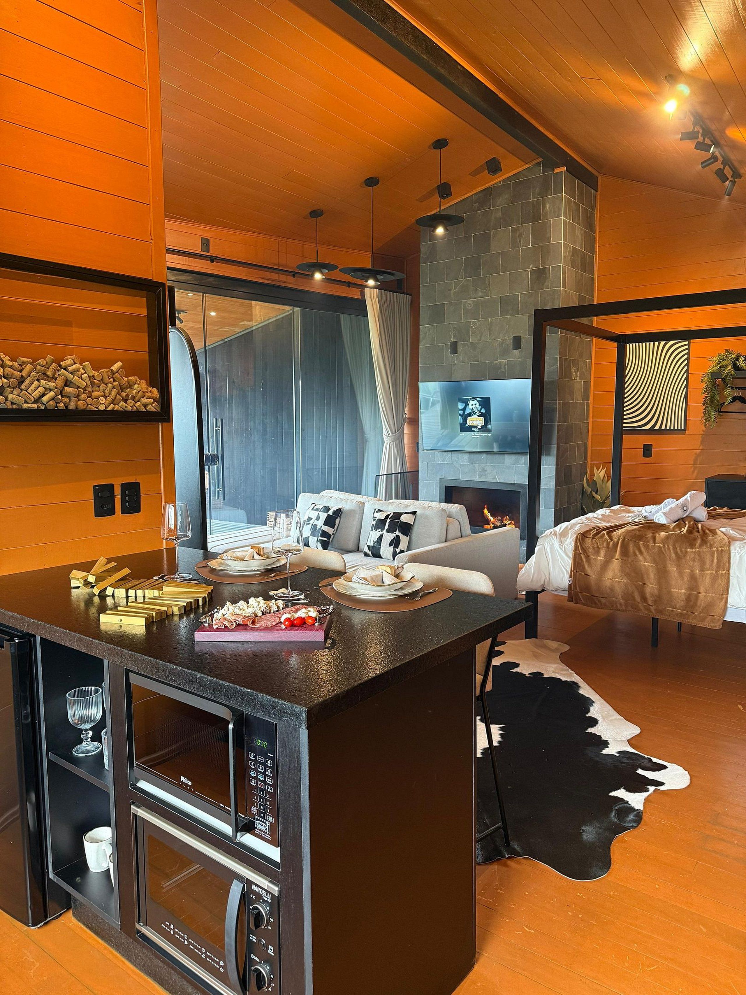 Een moderne woonkamer met een centraal eiland, een open haard en een vachten vloerkleed.