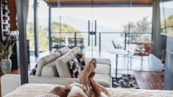 A bedroom with a large window overlooking a balcony.