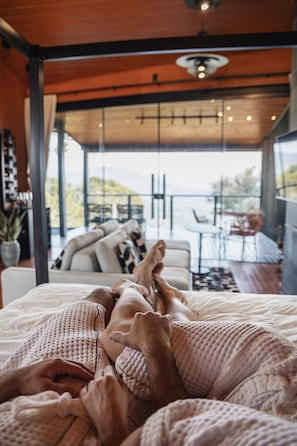 Ein Schlafzimmer mit einem großen Fenster und Balkonblick.