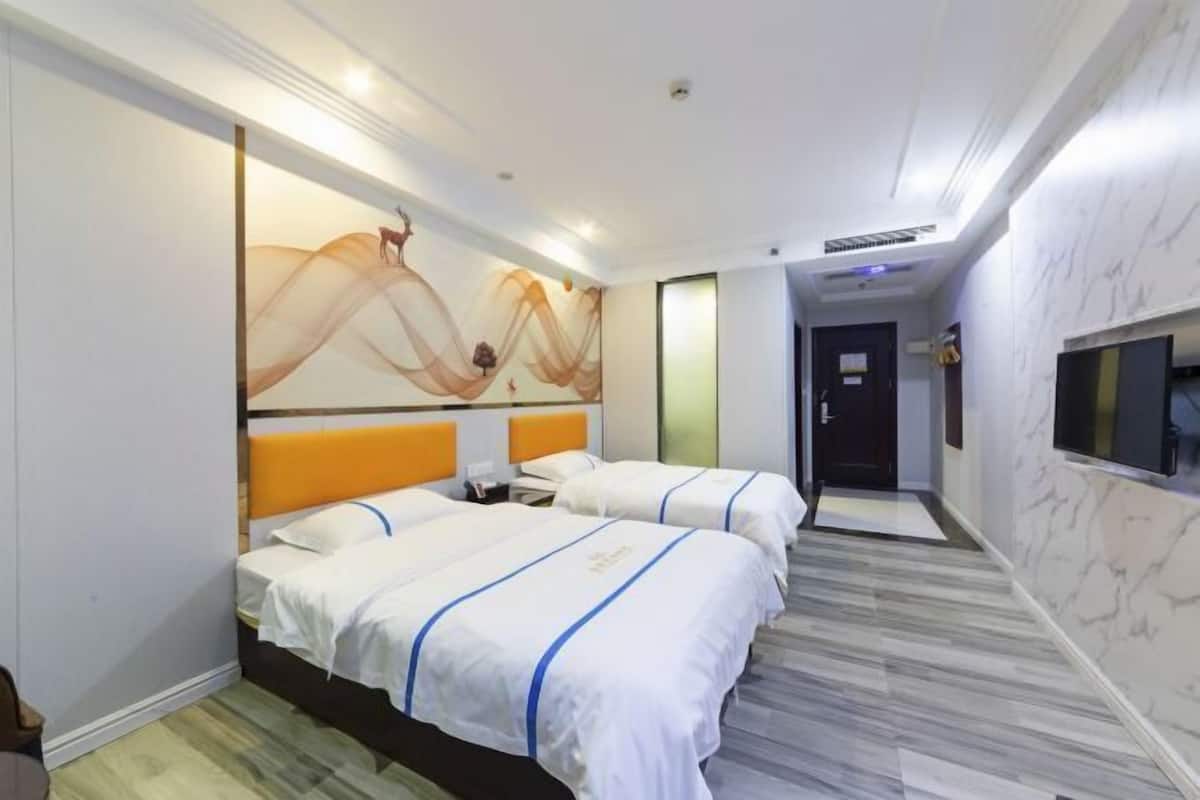 A hotel room with two beds, a large artwork on the wall, a TV mounted on the wall, and a marble floor.