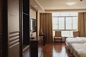 A hotel room with a large window, a desk with a television, a chair, and two beds. - Hengfeng Hotel (Qiyang)