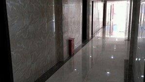 A corridor with reflective flooring and marble walls. - Hengfeng Hotel (Qiyang)
