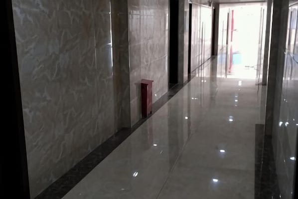 A corridor with reflective flooring and marble walls. - Hengfeng Hotel (Qiyang)