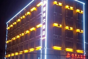A multi-story building with illuminated balconies and a sign indicating it is a hotel. - Hengfeng Hotel (Qiyang)