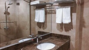 A bathroom with a sink, mirror, towel rack, and shower. - Hengfeng Hotel (Qiyang)