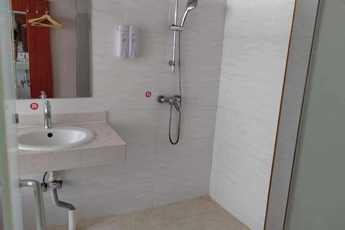 Un baño con lavabo, espejo y ducha.