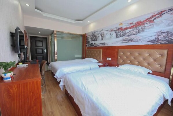 A hotel room with two beds, a wooden desk, a television, and a large painting on the wall. - Nanning Haoyuan Business Hotel (Nanning)