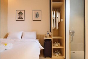 Comfortable accommodations feature a neatly made bed, a bedside table, and a closet.