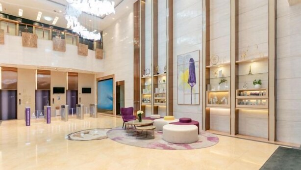A spacious lobby with a high ceiling, modern furniture, and a large digital display. - Lavande Hotels (Guangzhou Baiyun Yongtai Metro Station AnhuaHui) (Guangzhou)