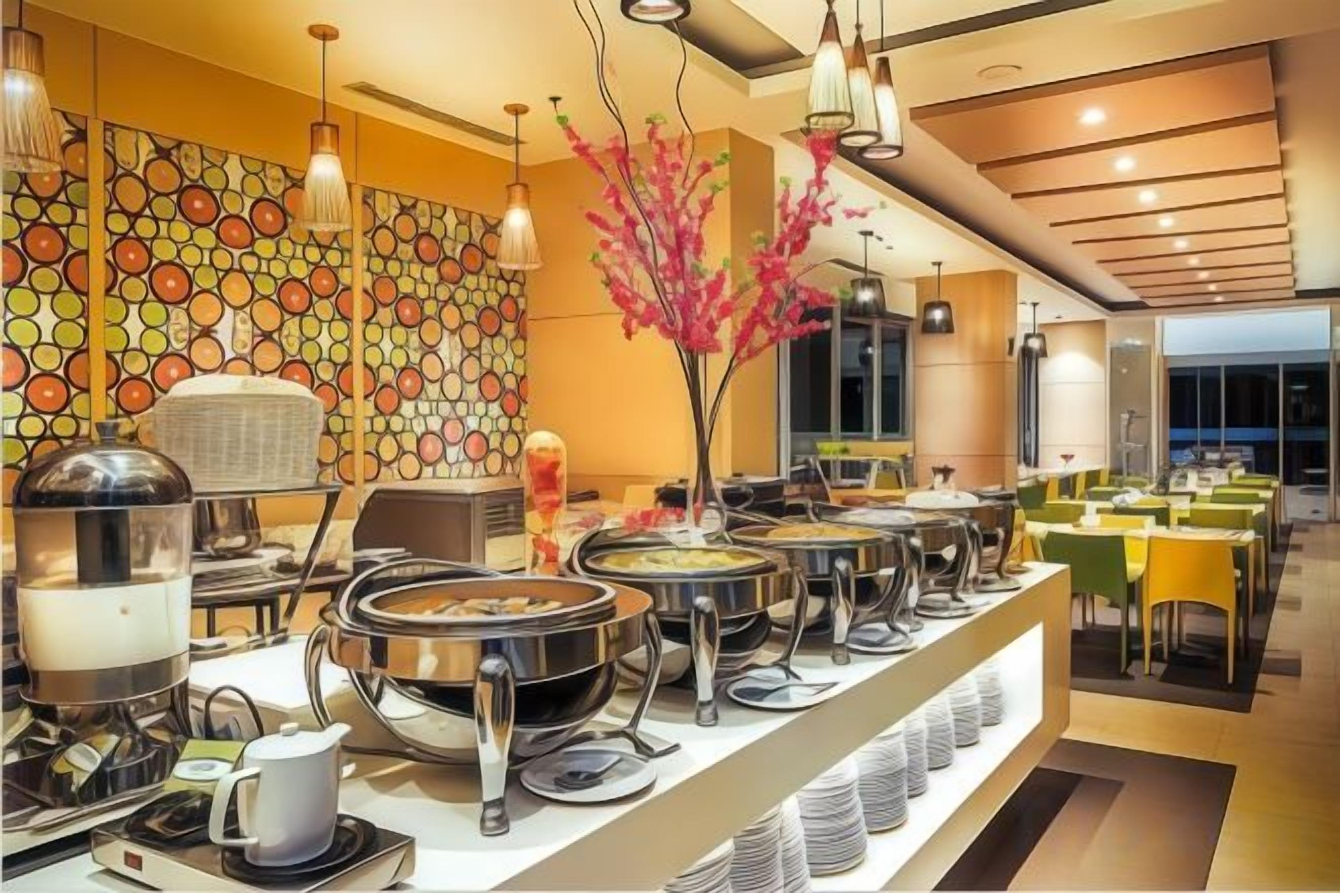 A buffet setup with multiple serving stations, a decorative wall with a circular pattern, and a modern interior design.