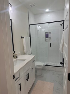 Een haardroger, handdoeken, shampoo, toiletpapier