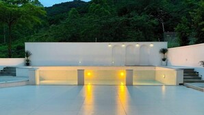 A spacious outdoor area with a modern design, featuring a flat surface and a series of steps leading up to a platform with lights. - Fagang Holiday Villa (Fogang)