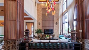 A spacious living area with a large sofa, a television, and a hanging light fixture. - Fagang Holiday Villa (Fogang)