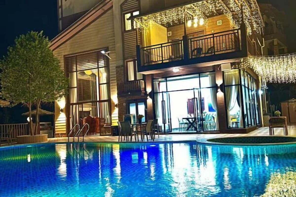 Un hôtel doté d’une piscine, d’un espace extérieur aménagé et d’une entrée bien éclairée.