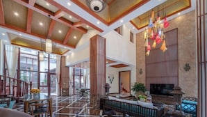 A spacious lobby with a high ceiling, a central seating area, and a television screen. - Fagang Holiday Villa (Fogang)
