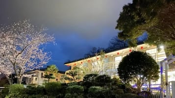 Un edificio de estilo arquitectónico tradicional, rodeado de jardines y árboles bien cuidados.