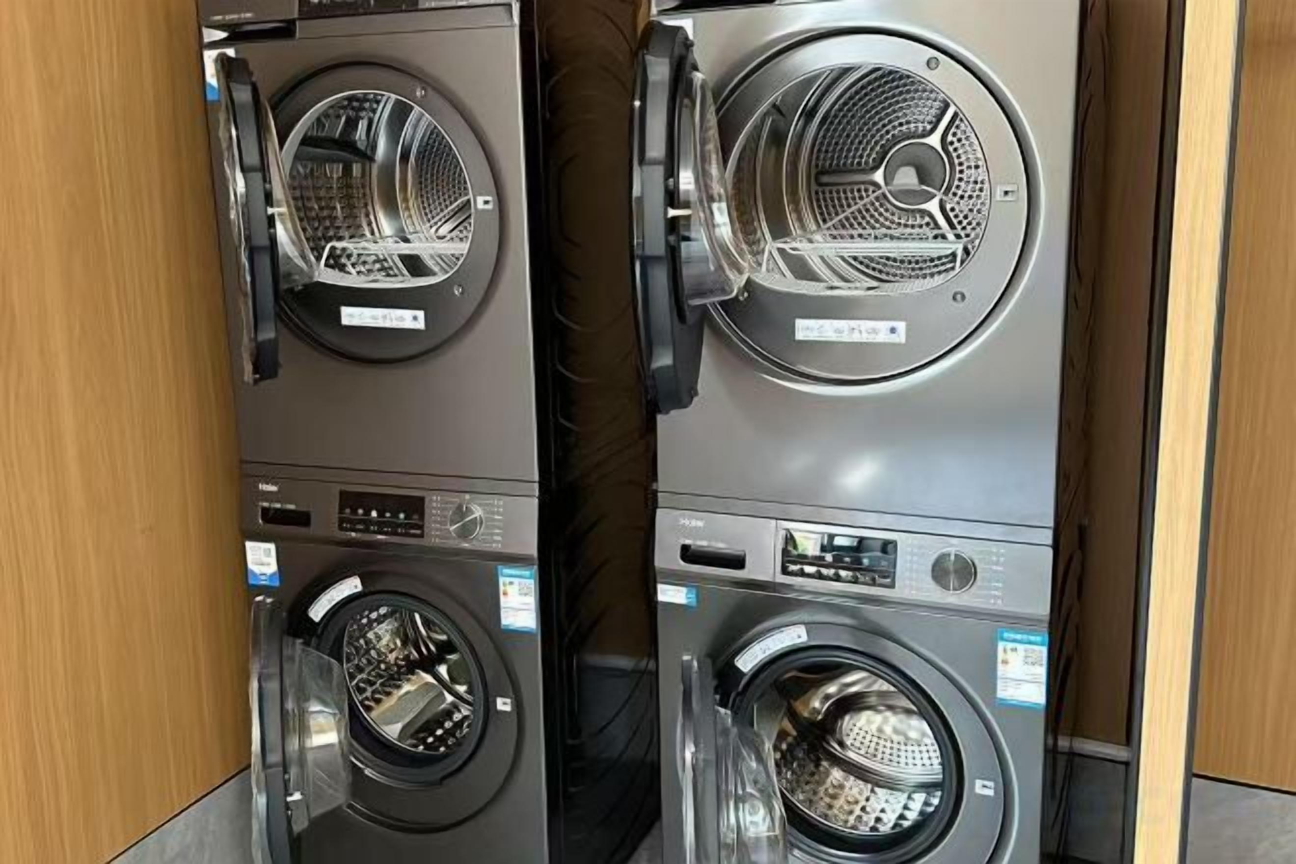 Two stacked front-loading washing machines in a commercial setting.