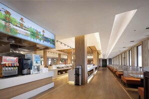 Un ristorante moderno con un lungo bancone, macchine da caffè e una zona con posti a sedere.