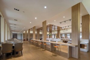 A modern dining area with high ceilings, long tables, and bar stools. - Liuhu Hotel (Hot Spring Garden Hotel) (Dezhou)