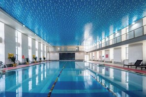A large indoor swimming pool with clear lanes, a high ceiling with a patterned design, and a view of the pool area. - Liuhu Hotel (Hot Spring Garden Hotel) (Dezhou)